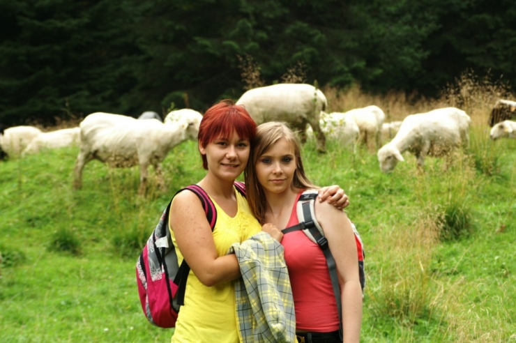 Dwie uczestniczki na tle pasących się owiec